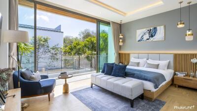 Modern bedroom with large glass windows, bed, and sitting area