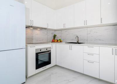 Modern white kitchen with appliances and marble backsplash