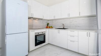 Modern white kitchen with appliances and marble backsplash