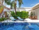 Outdoor area with pool, lounge chairs, and greenery