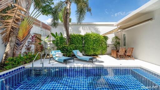 Outdoor area with pool, lounge chairs, and greenery