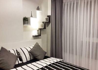 Modern bedroom with striped bedding and wall-mounted shelves
