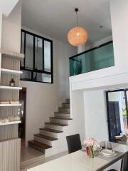 Modern and spacious main living area with high ceilings and stylish staircase