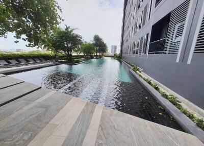 Outdoor pool area alongside a modern apartment building