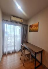 cozy study room with desk and chair, window with sheer curtain, and air conditioning unit