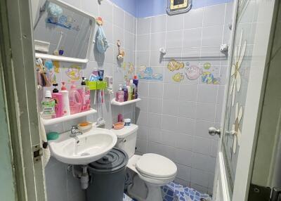 Small bathroom with sink, toilet, and various toiletries