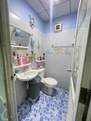 Small bathroom with sink, toilet, and various toiletries