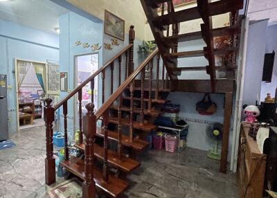 Wooden staircase in a living area with visible rooms