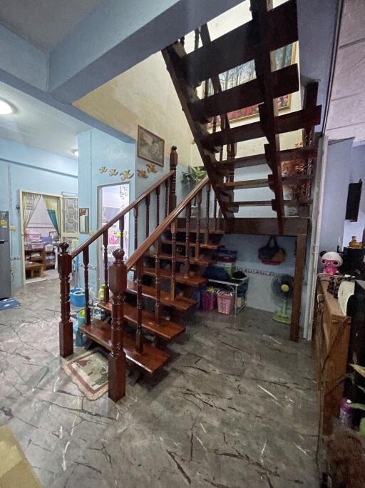 Wooden staircase in a living area with visible rooms