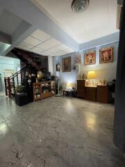 Spacious living room with staircase and decorated walls