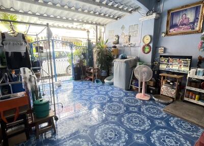 covered living area with blue patterned floor tiles and household items