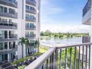 Balcony with view of modern apartment building and serene lakeside