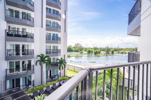 Balcony with view of modern apartment building and serene lakeside