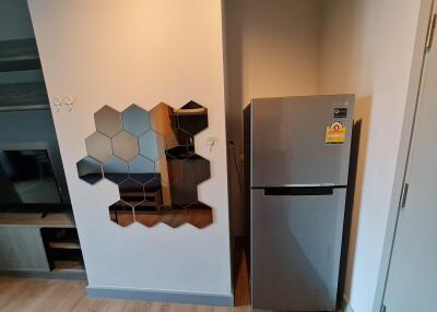 Modern kitchen corner with refrigerator and decorative wall mirror