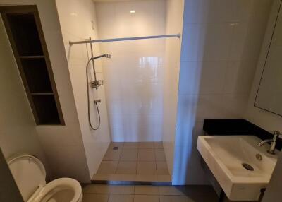 A modern bathroom with a shower area, toilet, and sink.