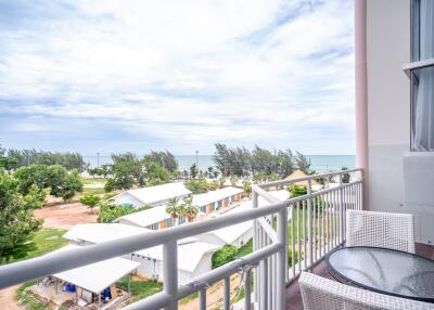 A balcony with a scenic view of the sea and greenery