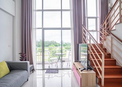 Spacious and well-lit living room with high ceilings and large windows