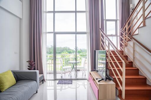 Spacious and well-lit living room with high ceilings and large windows