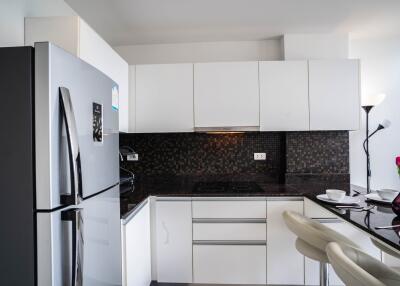 Modern kitchen with sleek white cabinetry and stainless steel refrigerator