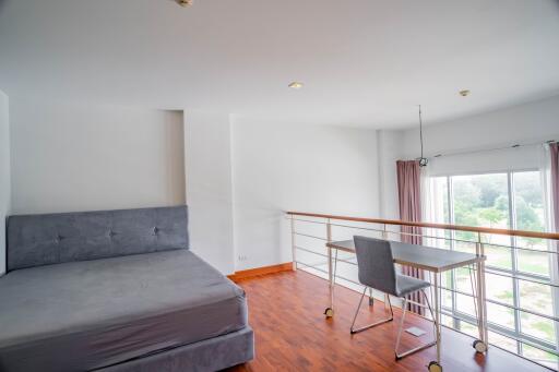 Bright bedroom with a bed, a desk and chair near a large window