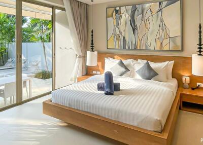 Modern bedroom with large bed, artwork, and view of private outdoor patio