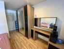 Bedroom with wooden floor, wardrobe, and dresser