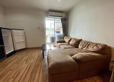 living room with brown sectional sofa, hardwood floor, open sliding door to balcony