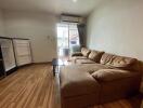 living room with brown sectional sofa, hardwood floor, open sliding door to balcony