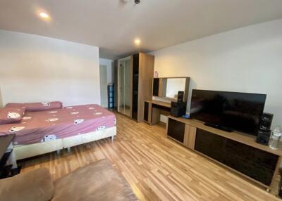 Bedroom with bed, wardrobe, television, and wood flooring