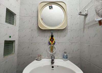 Small bathroom with a round sink, mirror, and towel rack