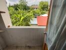 Small balcony with tiled floor and view of greenery