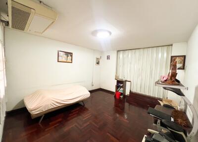 Bedroom with framed pictures, air conditioning unit, and computer desk