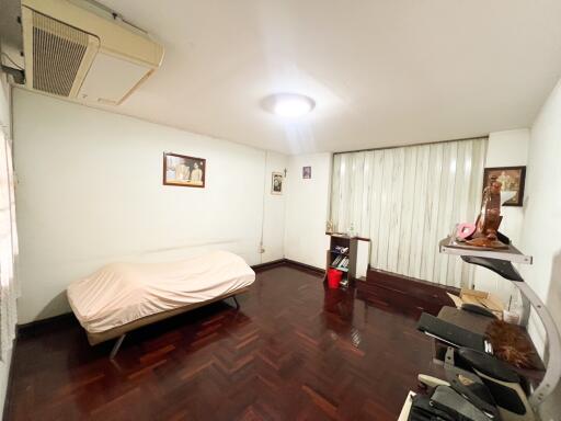 Bedroom with framed pictures, air conditioning unit, and computer desk