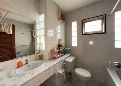 Modern bathroom with sink, toilet, and window