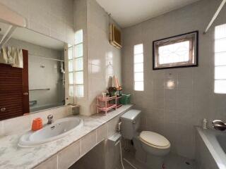 Modern bathroom with sink, toilet, and window