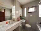 Modern bathroom with sink, toilet, and window