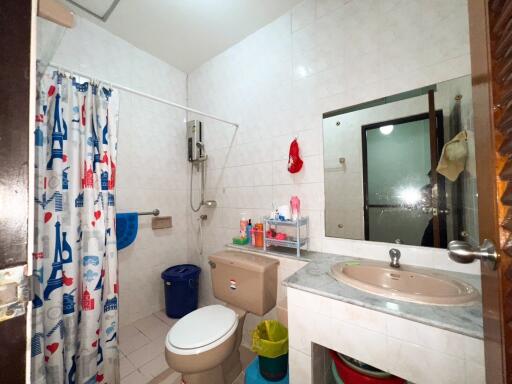 A bathroom with shower, sink, and toilet