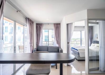 Modern living area with large windows and a view of the bedroom