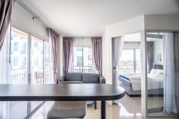 Modern living area with large windows and a view of the bedroom