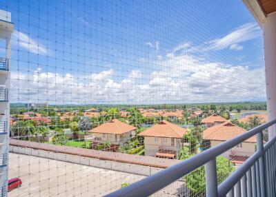 View from balcony of residential area with red-roofed houses and greenery