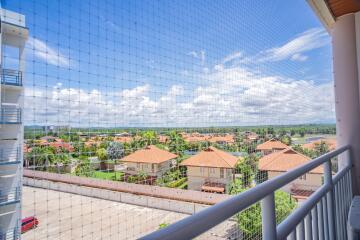 View from balcony of residential area with red-roofed houses and greenery