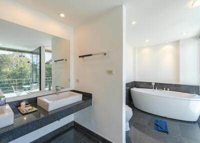 Modern bathroom with double sink, large mirror, and freestanding bathtub