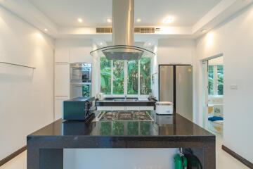 Modern kitchen with island, large windows, and stainless steel appliances