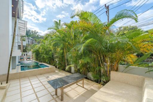 Patio with swimming pool and lush greenery