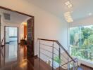 View of a hallway leading to rooms with wooden floors and a large window