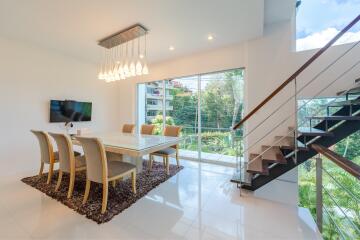 Modern dining space with a large window and staircase