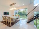 Modern dining space with a large window and staircase