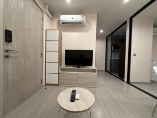 Modern living room with TV, air conditioning, and a small table