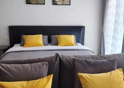 Modern bedroom with grey bed and yellow accent pillows
