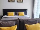 Modern bedroom with grey bed and yellow accent pillows